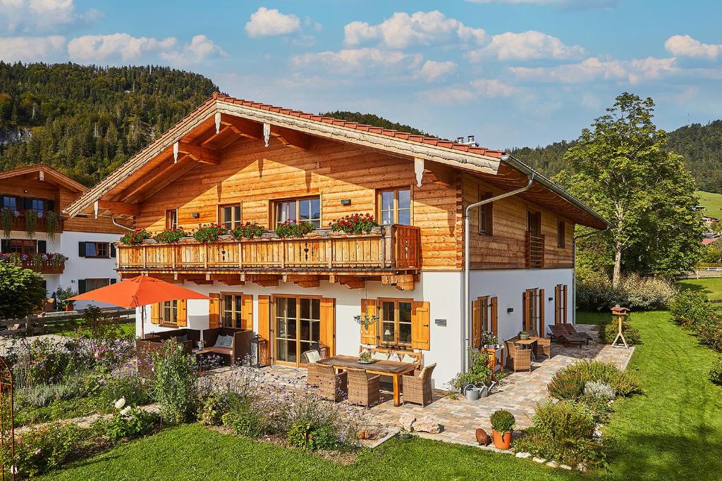 a large wooden house with a balcony on top of it at Landhauswohnung Dosbach in Reit im Winkl