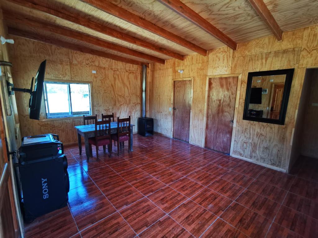 una habitación vacía con una mesa y sillas. en Cabañas Orillas Del Nilahue, en Riñinahue
