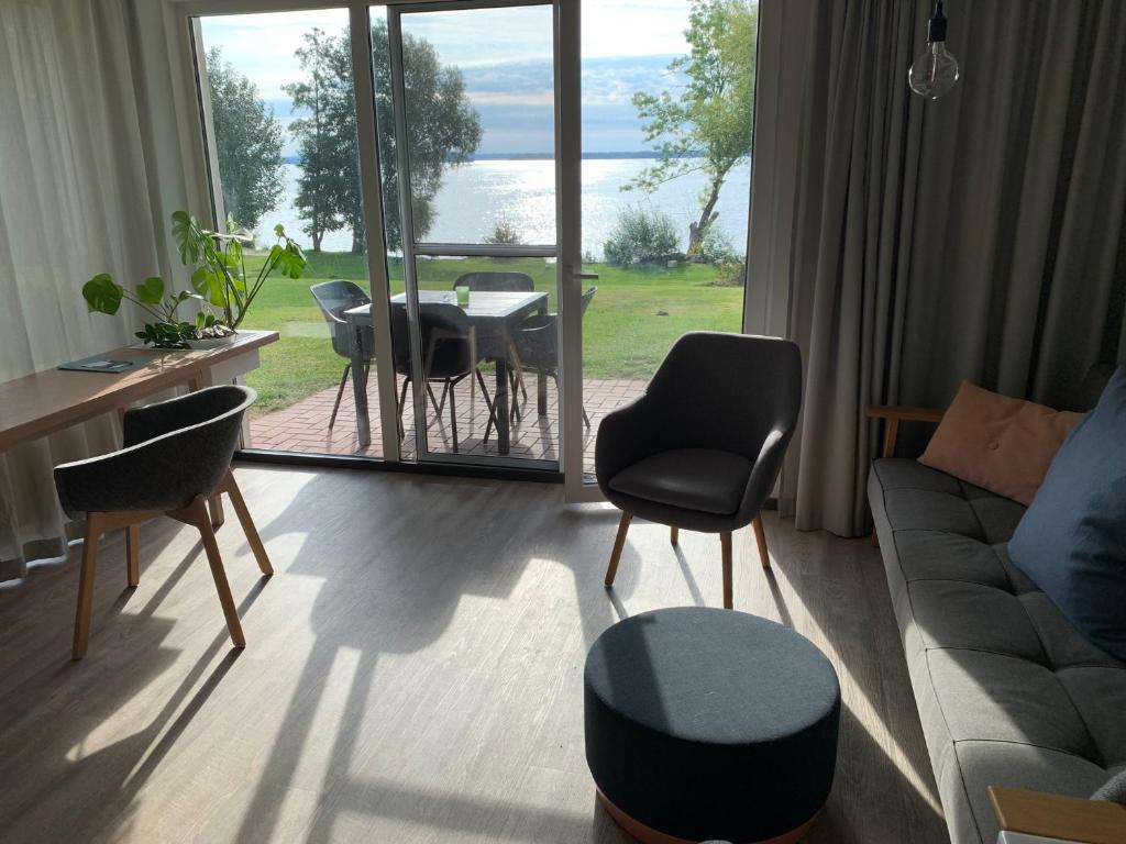 sala de estar con sofá, mesa y sillas en Ferienwohnung am See, en Ascheberg