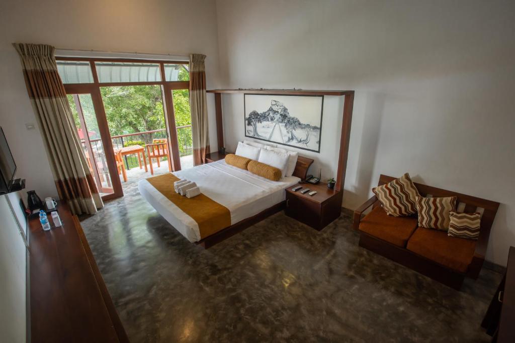 Postel nebo postele na pokoji v ubytování Sigiriya Wewa Addara Hotel - Hotel By The Lake