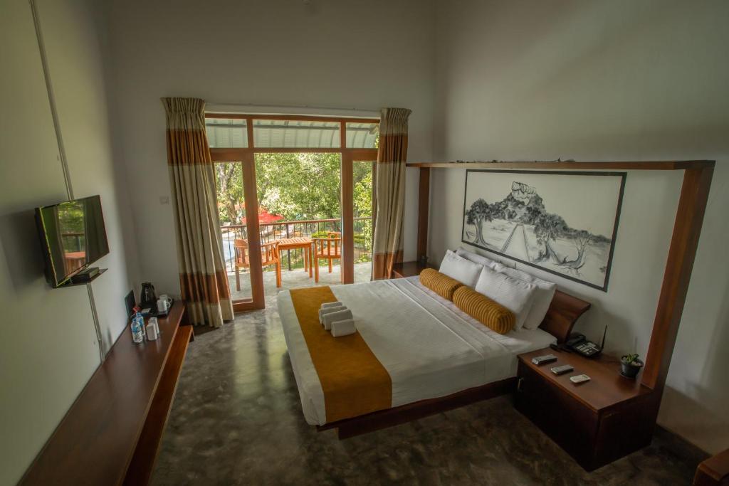 Postel nebo postele na pokoji v ubytování Sigiriya Wewa Addara Hotel - Hotel By The Lake