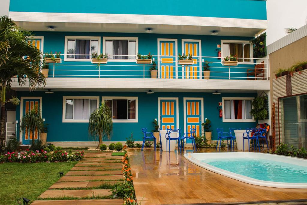 a house with a swimming pool in front of it at Pousada No Meio do Mundo in Anchieta