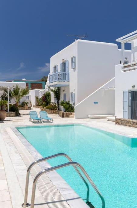 a large swimming pool in front of a building at 'Nepheli' Mykonean Suite in Ornos
