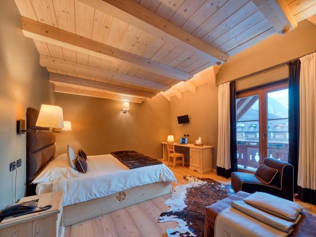 a bedroom with a bed and a large window at Agriturismo Rini in Bormio