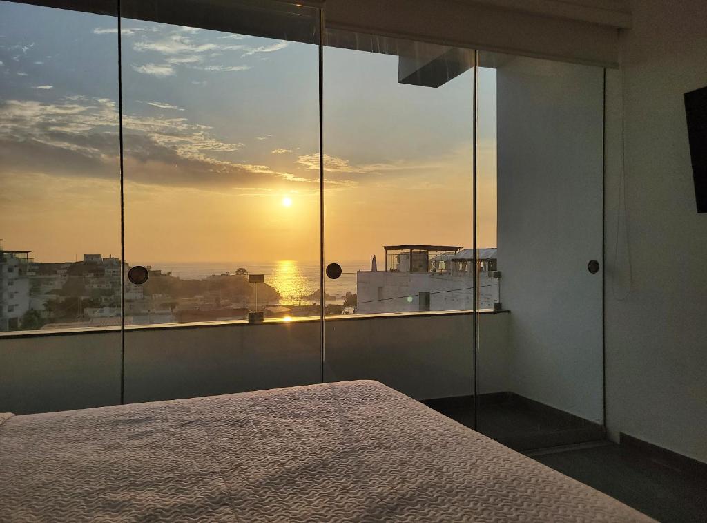 1 dormitorio con cama y vistas a la puesta de sol en ALTEA HOTEL - San Bartolo, en San Bartolo