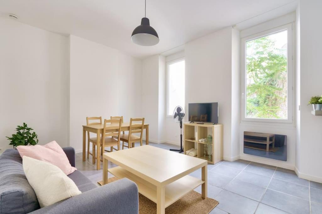 uma sala de estar com um sofá e uma mesa em Lovely apartment located 10 min from the sea side em Marselha
