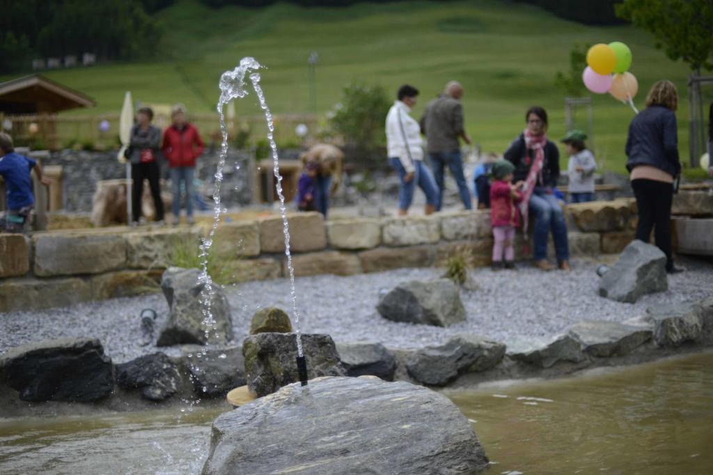 a group of people standing around a water fountain at Alpengasthof zur Post in Schattwald