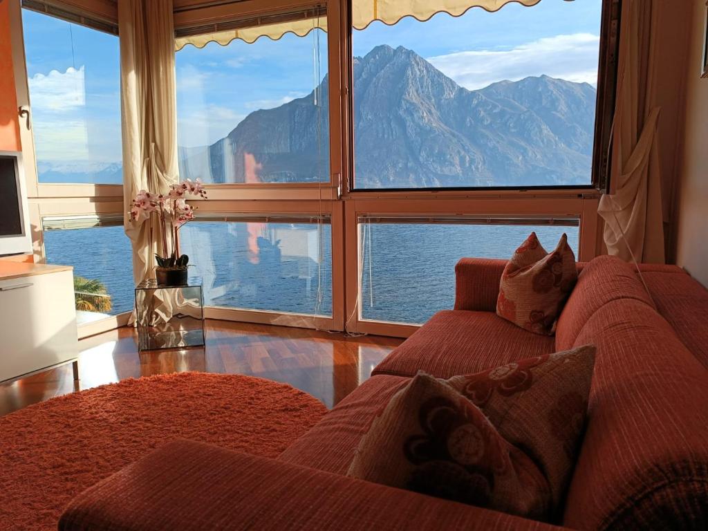 a living room with a couch and a large window at Patty ZU - Lakeside apartment in Riva di Solto