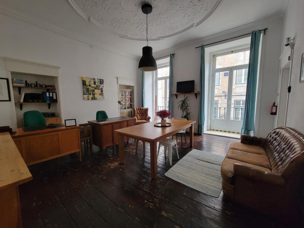 ein Wohnzimmer mit einem Tisch und einem Sofa in der Unterkunft Boho Guesthouse - Rooms & Apartments in Lissabon