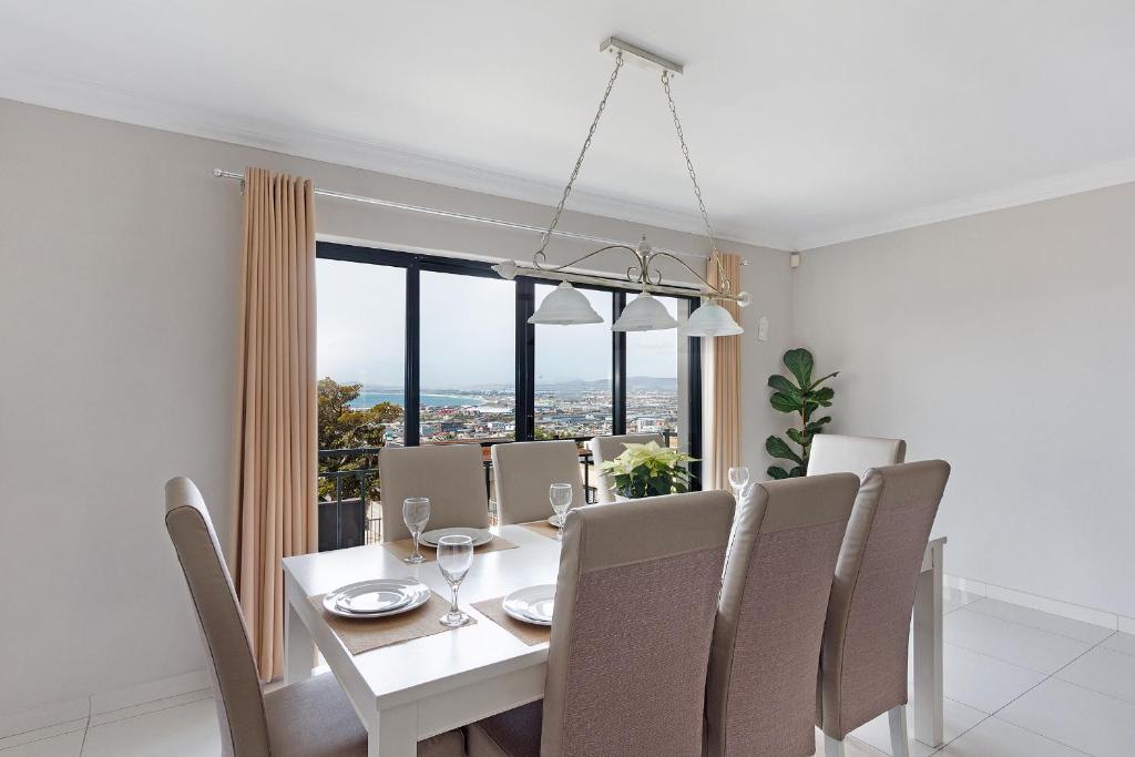 una sala da pranzo con tavolo e sedie bianchi di STAR APARTMENTS a Città del Capo