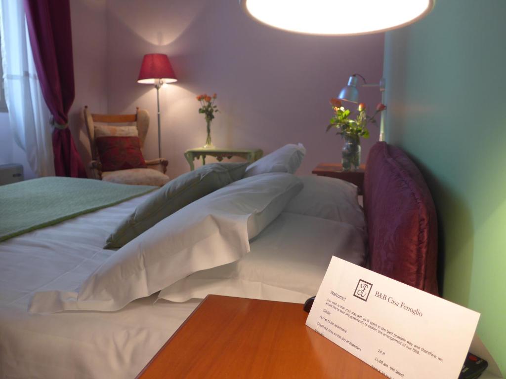 a hotel room with a bed with a sign on a table at B&B Casa Fenoglio in Ventimiglia