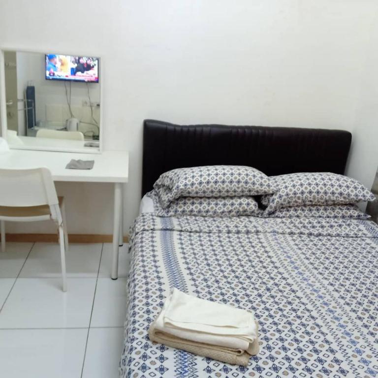 a bedroom with a bed and a desk and a sink at jm in Shah Alam