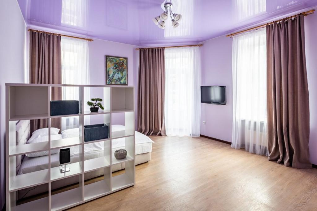 リヴィウにある3 кім квартира по вулиці Котлярська біля Оперного театруの紫の壁と白い家具が備わるベッドルーム1室、窓