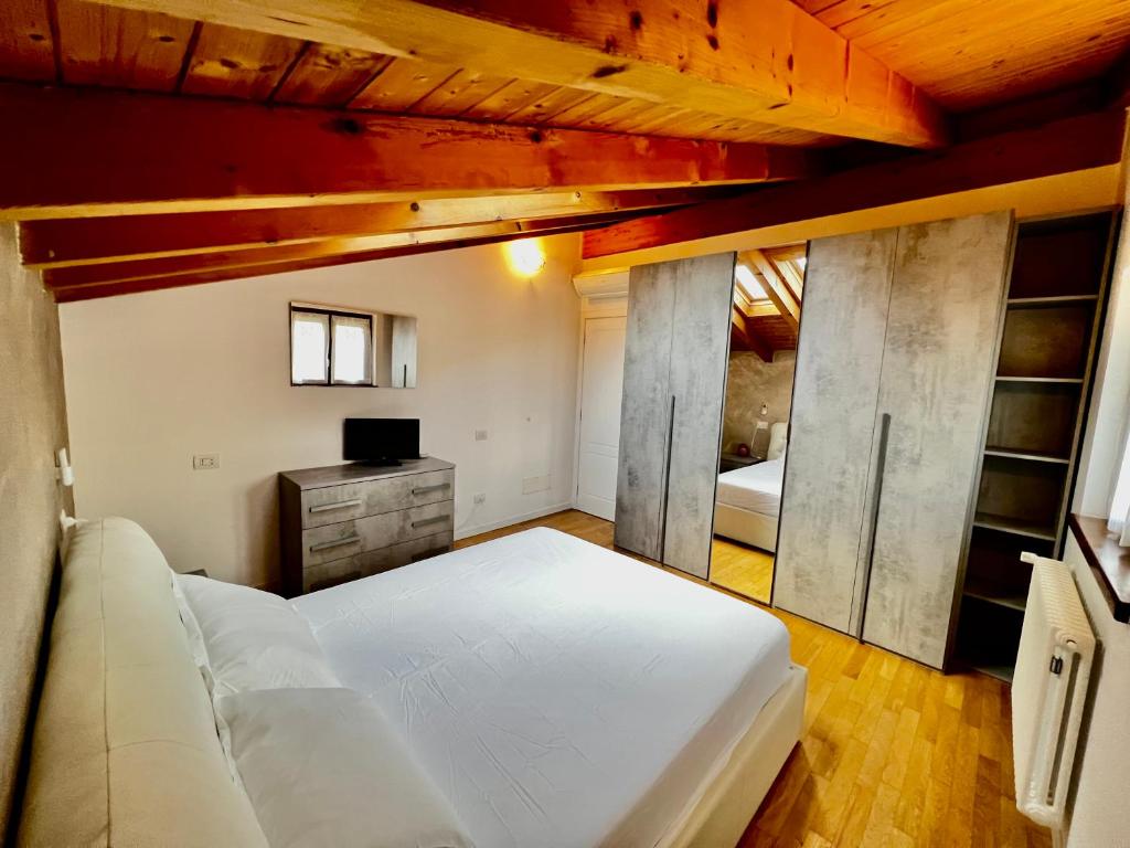 una camera da letto con un grande letto bianco e soffitti in legno di Sonhozinho House Colico a Colico