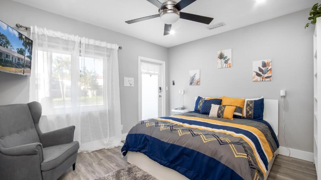 a bedroom with a bed and a ceiling fan and a chair at Cozy 1 BDR Unit by Beach, Mall, & Downtown FTL in Fort Lauderdale