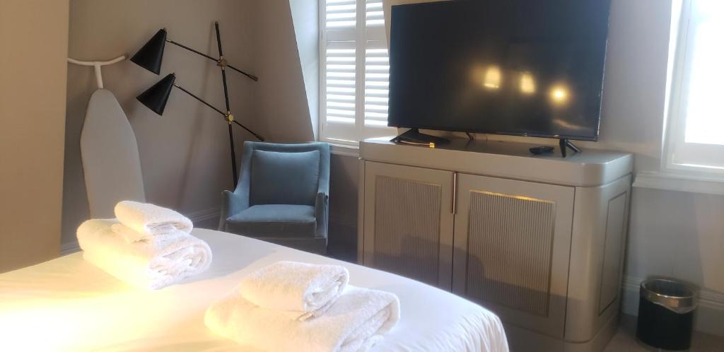 a hotel room with towels on a bed with a tv at Henrietta House, a member of Radisson Individuals in Bath
