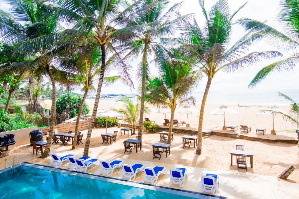uitzicht op het zwembad en het strand van het resort bij Nico Beach Hotel in Hikkaduwa