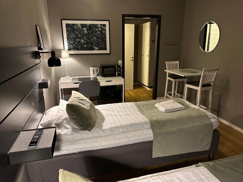 1 dormitorio con cama, escritorio y cocina en Hotel B&B Gränden en Skellefteå