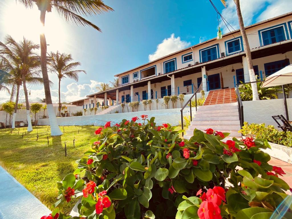 um resort com flores vermelhas em frente a uma piscina em Montepascual Ecovillage em Lagoinha