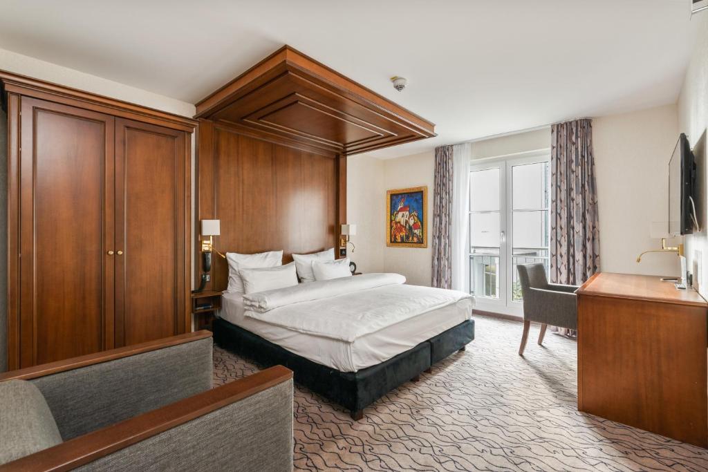 a hotel room with a bed and a desk at AdvaStay by KING's in Munich