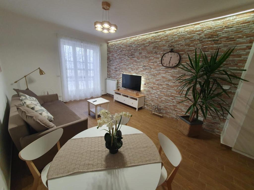 un soggiorno con tavolo e muro di mattoni di Casa eNNe, Appartamento Vicino Centro e Juventus Stadium a Torino