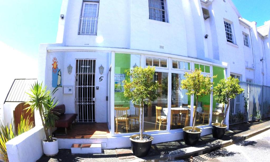 un edificio blanco con macetas delante de él en House on the Hill en Ciudad del Cabo
