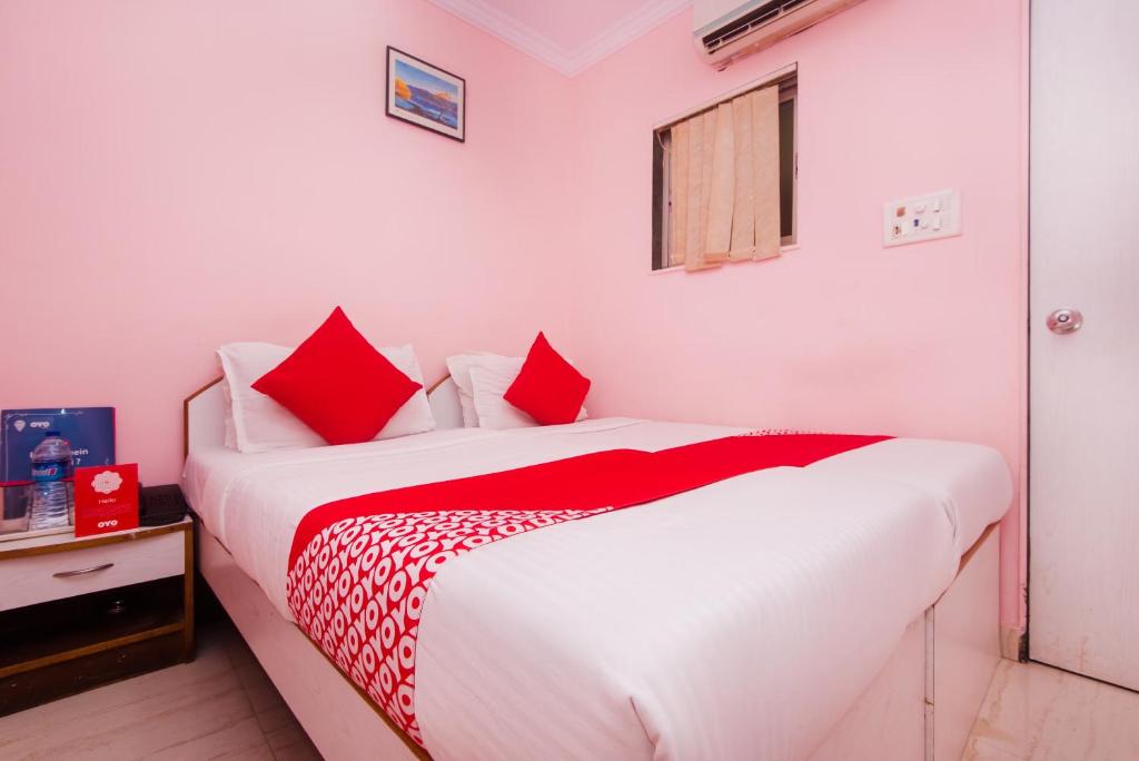 een slaapkamer met een groot wit bed met rode kussens bij Green Grass Homestay in Sigiriya