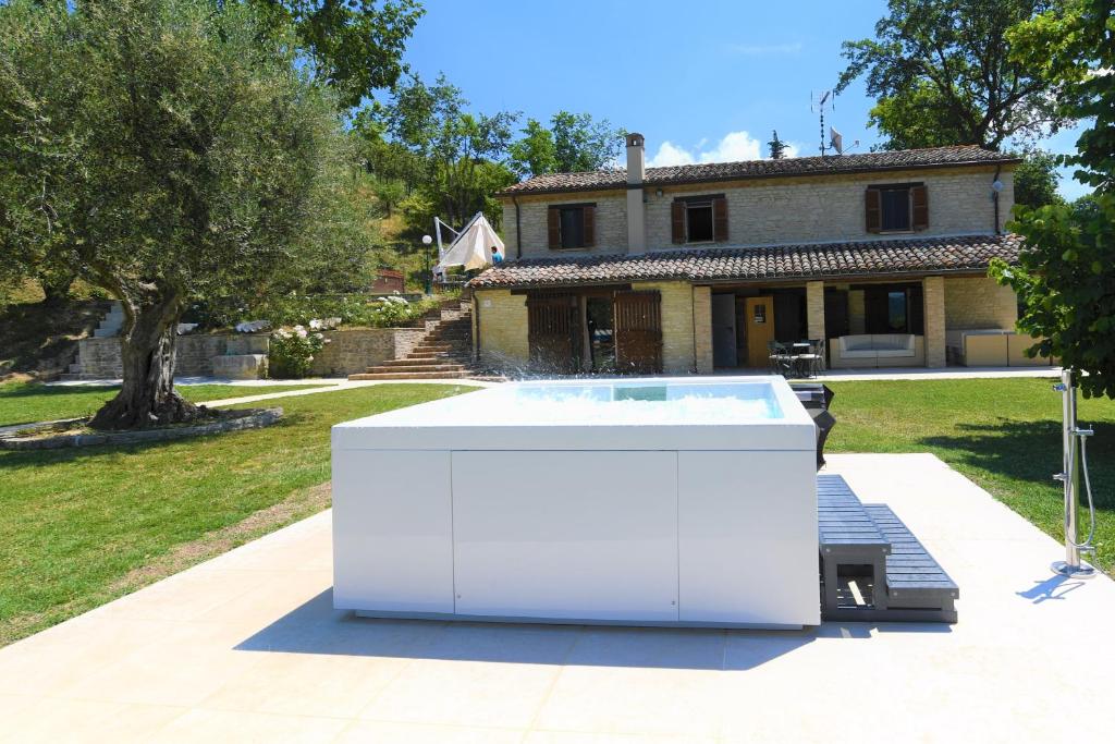 una gran bañera de hidromasaje blanca frente a una casa en Villa Anna Heated Pool and two jacuzzi, en SantʼIppolito