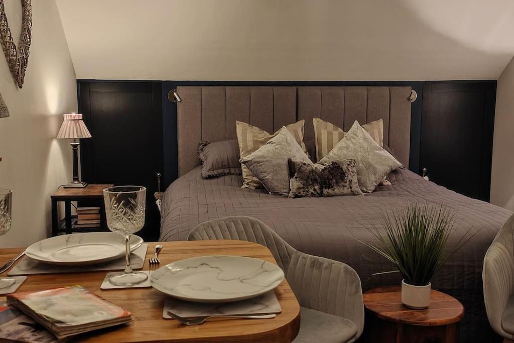 a bedroom with a bed with a table with plates on it at Cosy Country Retreat in the Brecon Beacons in Crickhowell