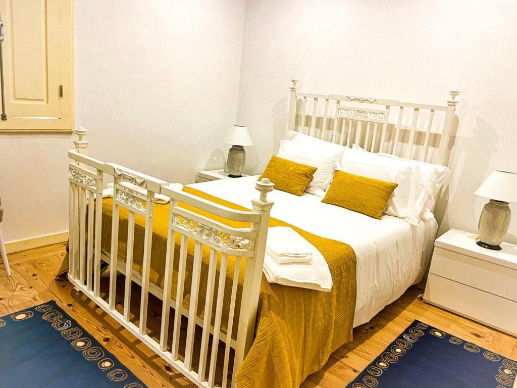 a white bed with yellow pillows in a bedroom at Quintinha de Pinouco in Resende