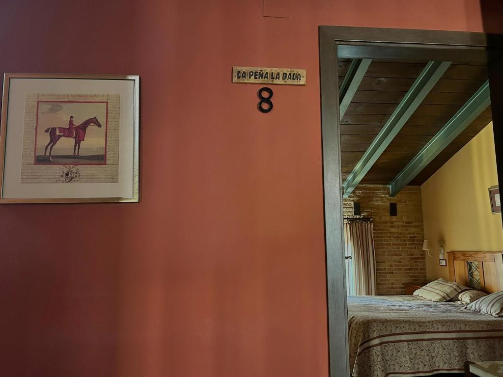 una habitación con una puerta con una foto de un caballo en la pared en Hostal meson del rey, en Olocau del Rey