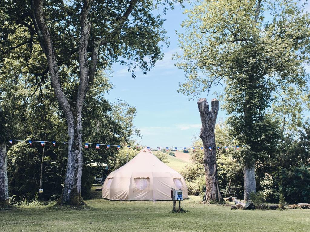 een witte tent in een veld met bomen bij Camping d'artagnan in Margouët-Meymès