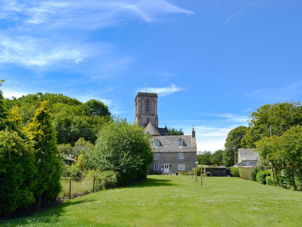 an old house with a tower on top of a field at Sweet Pea Cottage in Kingston