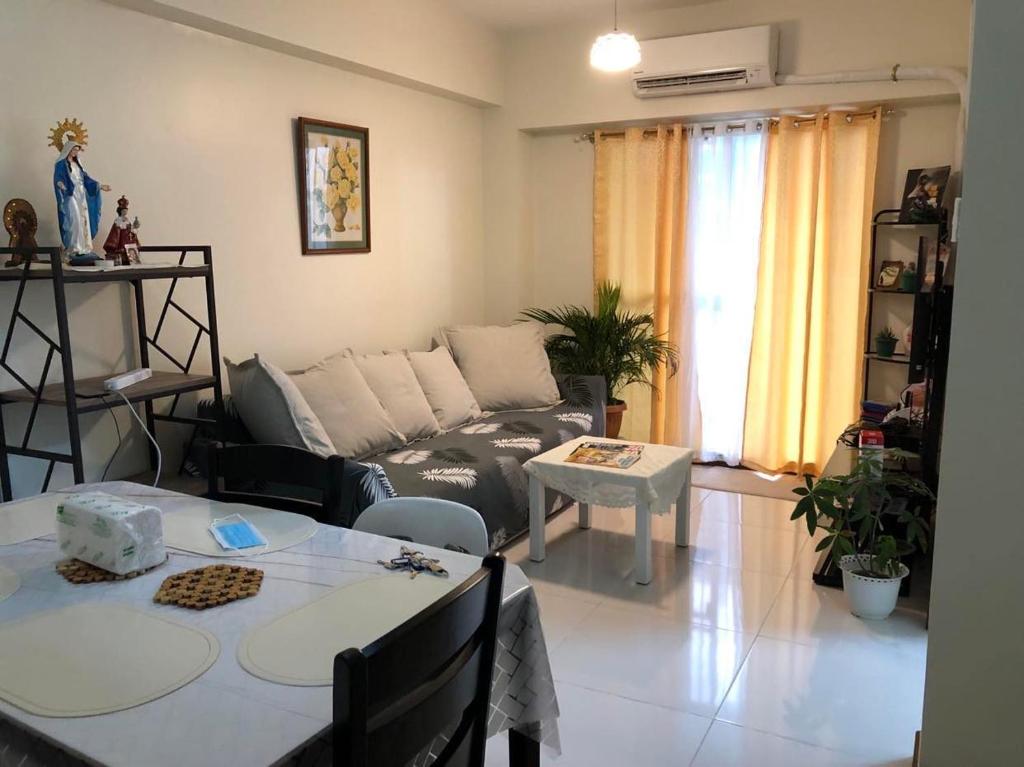 a living room with a couch and a table at 2BR Condo Unit at Prisma Residences in Manila