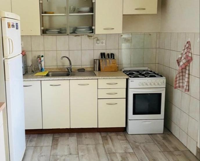 a kitchen with white cabinets and a stove top oven at Vila Safin in Poprad