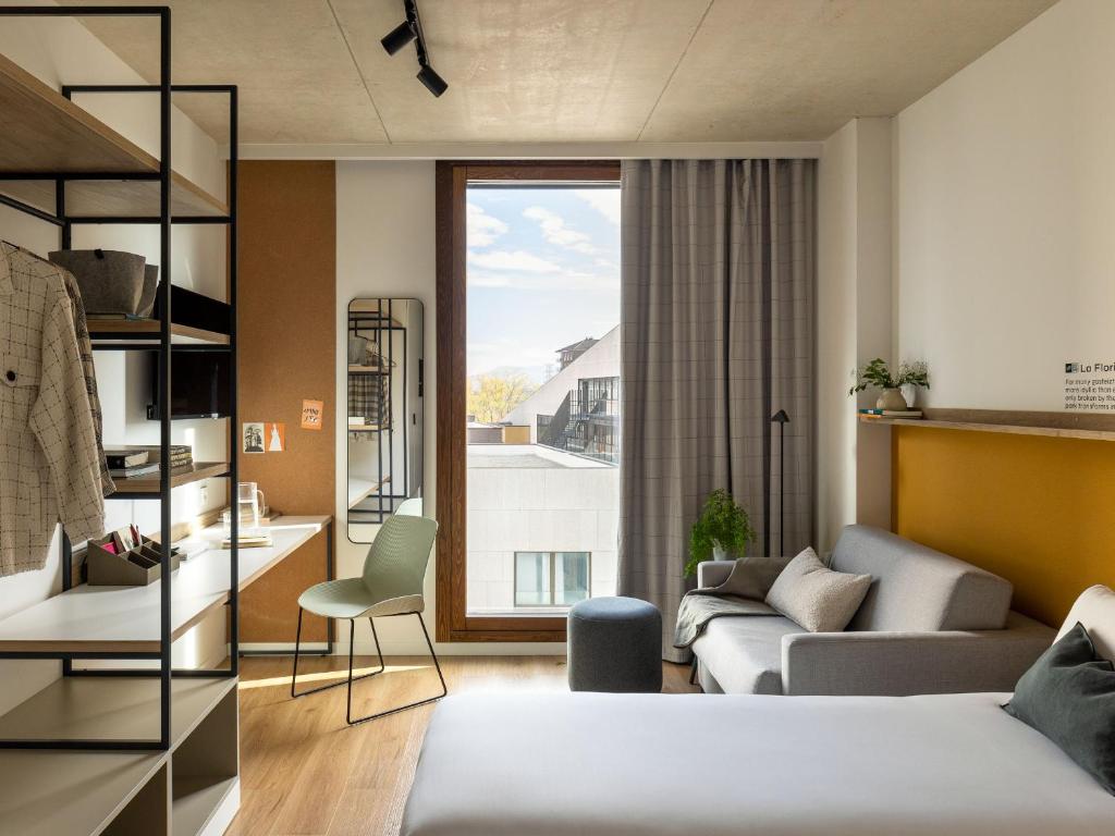 ein Schlafzimmer mit einem Bett und ein Wohnzimmer in der Unterkunft Kora Green City - Aparthotel Passivhaus in Vitoria-Gasteiz