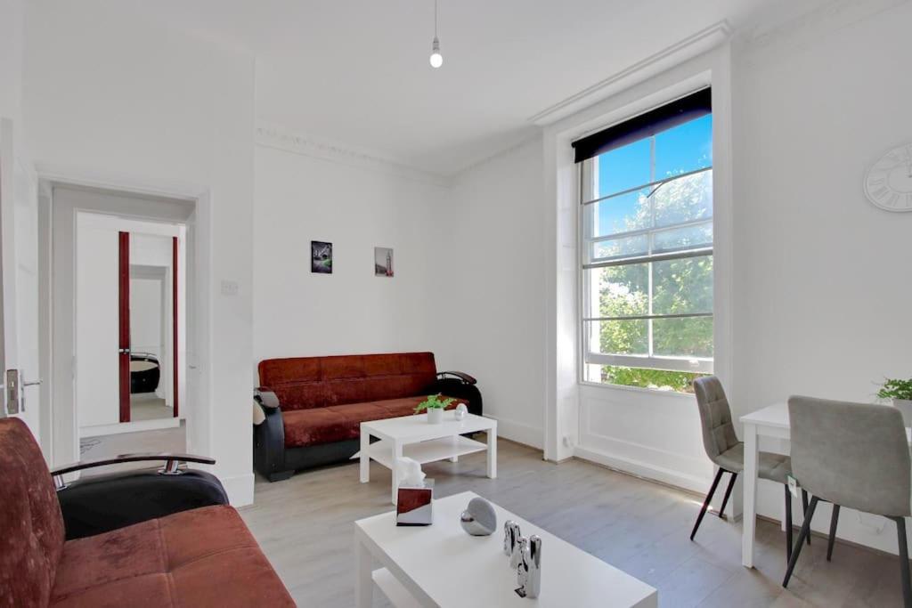 a living room with a couch and a table at Hamilton Apartments hosted by Maysa London in London