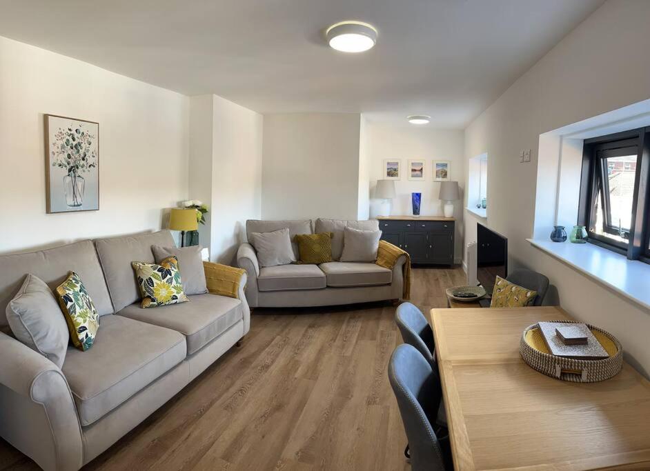 un soggiorno con divano e tavolo di No5 at 53 - 2 bed apartment in Leek, Staffs Peak District a Leek