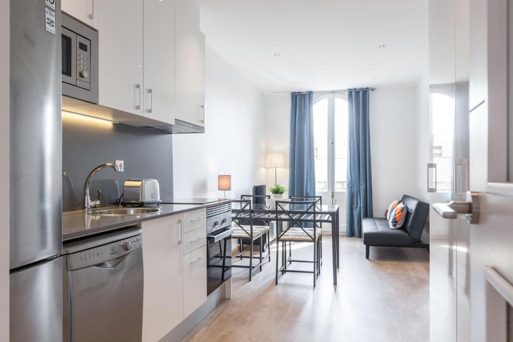 uma cozinha com um lavatório e uma mesa num quarto em Bright Apartment with Balconies em Barcelona