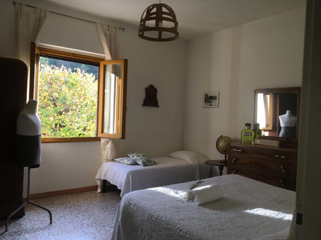1 dormitorio con 2 camas y ventana en Welcome in Toscana, en Polcanto