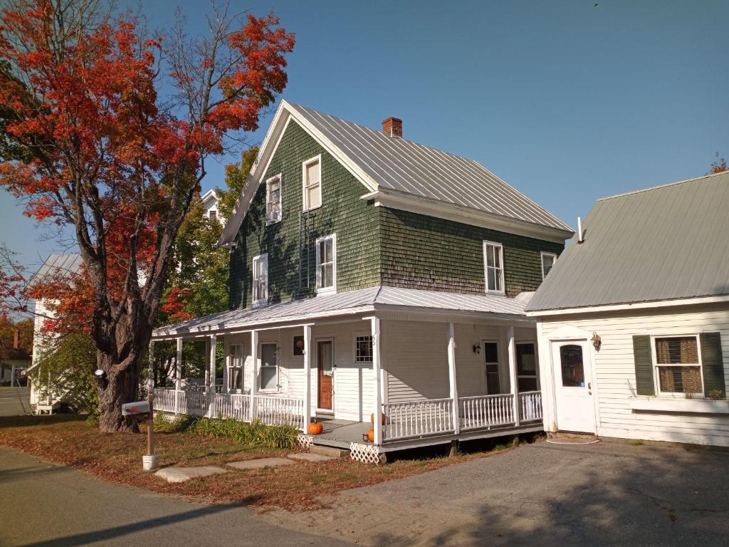 une grande maison verte et blanche avec un arbre dans l'établissement Terrapin Hostel, à Kingfield