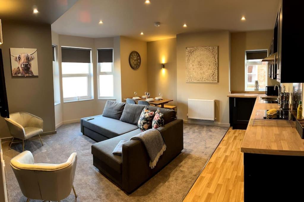 a large living room with a couch and a kitchen at University Duplex • Sleeps 6 in Loughborough