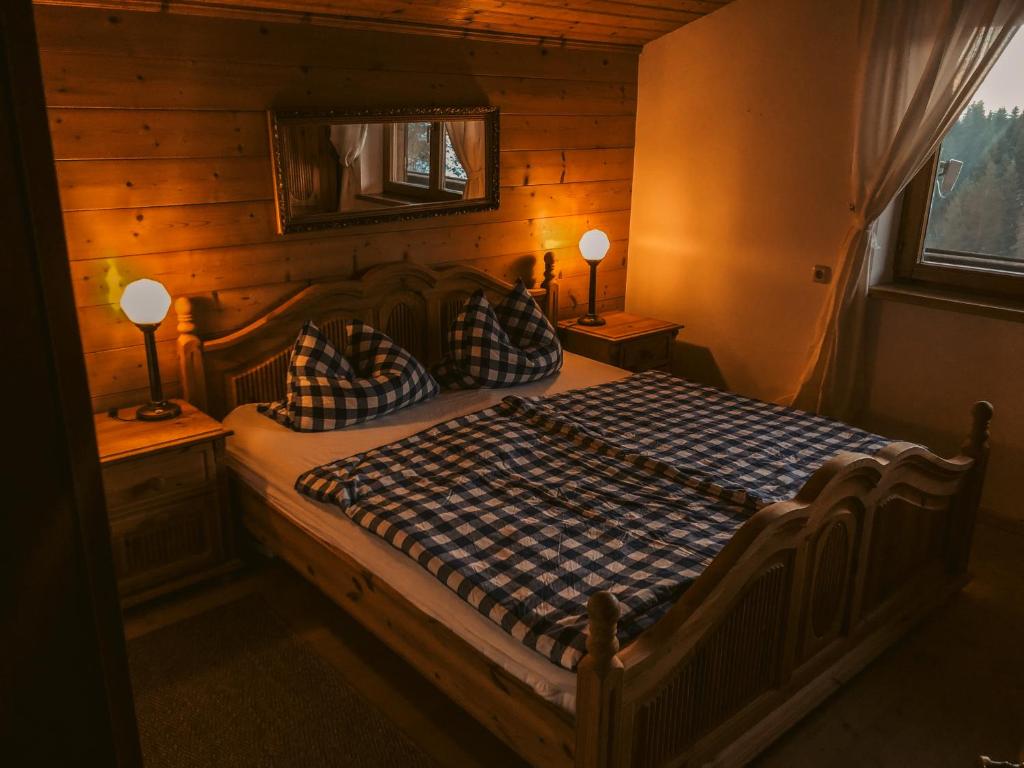 um quarto com uma cama num quarto com paredes de madeira em Kuhlinarik Apartment em Prama