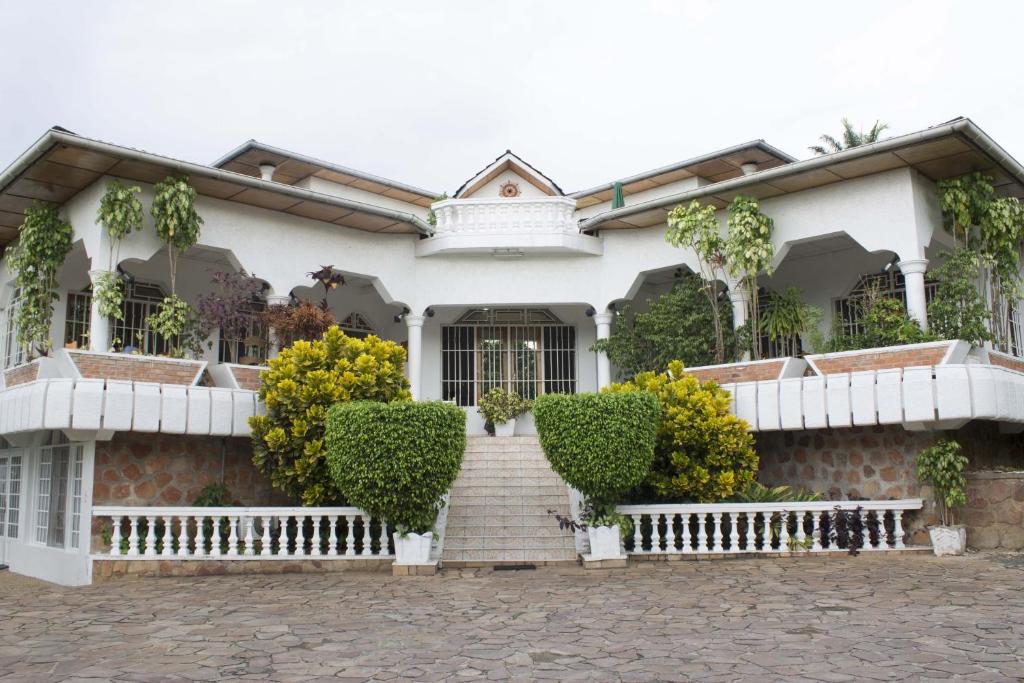 uma casa branca com uma escada em frente em Kiriri Residence Hotel em Bujumbura