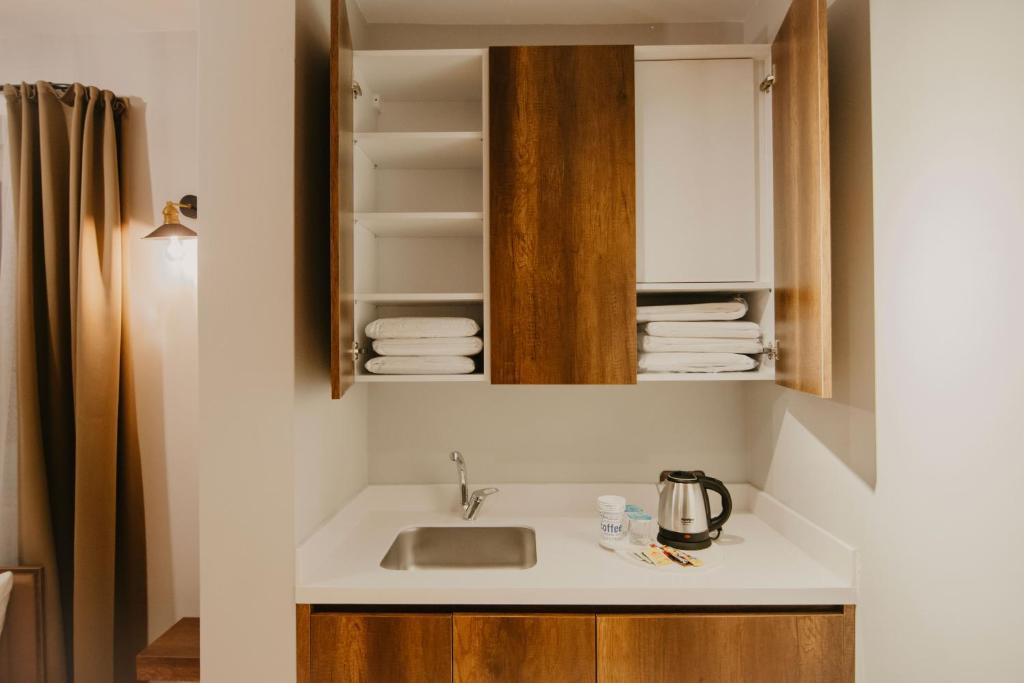 eine Küchentheke mit einem Waschbecken und einem Spiegel in der Unterkunft Copper House in Trabzon