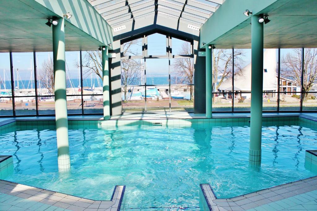 a swimming pool with blue water in a building at VVF Lac Léman Évian-les-Bains in Évian-les-Bains