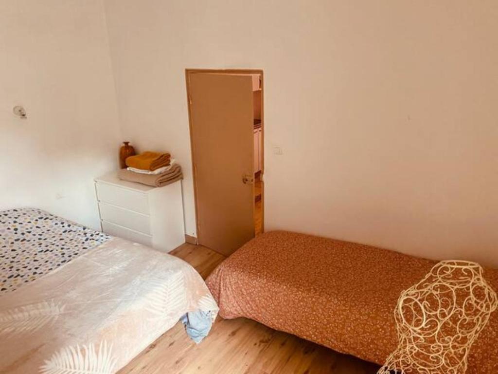 a small bedroom with two beds and a door at Coquet studio coeur de ville au calme in Millau