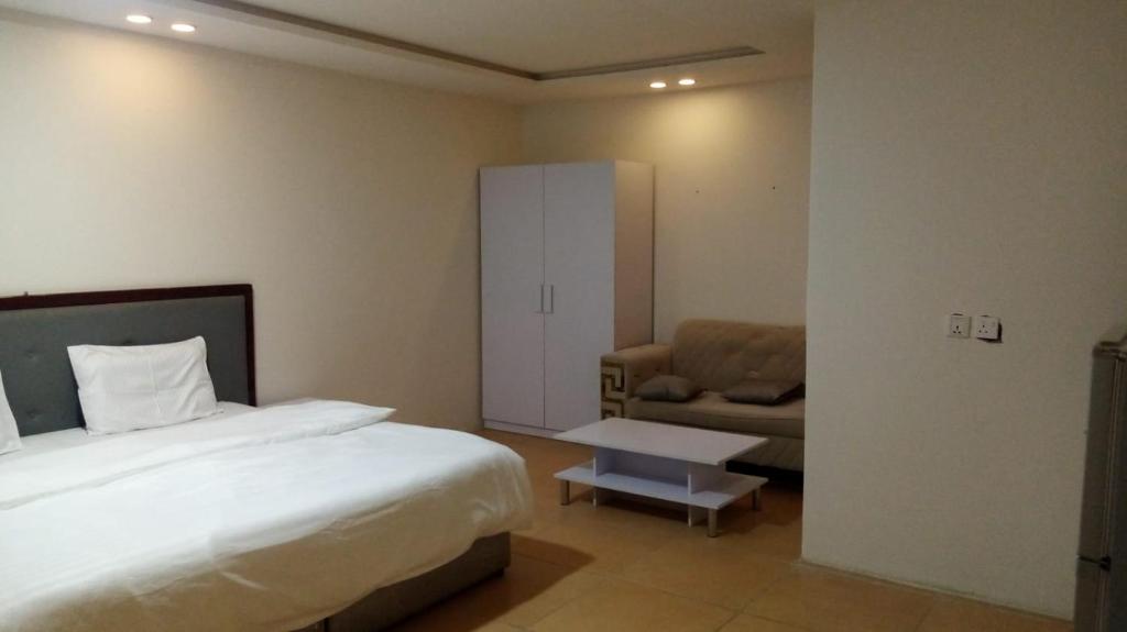 Habitación de hotel con cama y sofá en اغصان الريف لشقق المفروشة, en Riad