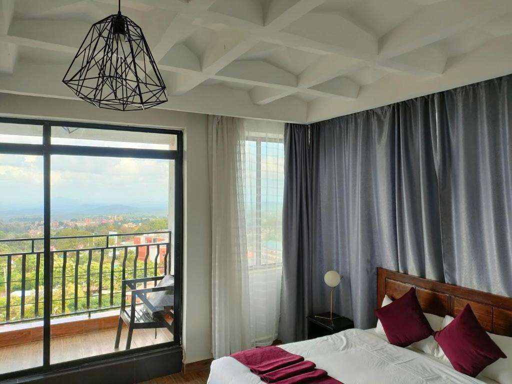 una camera con un letto e una grande finestra di THE HOTEL EZRI a Meru