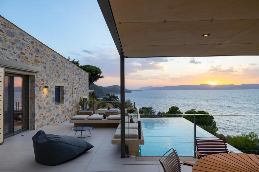a house with a swimming pool and a view of the ocean at Kechria Bay Villas in Skiathos